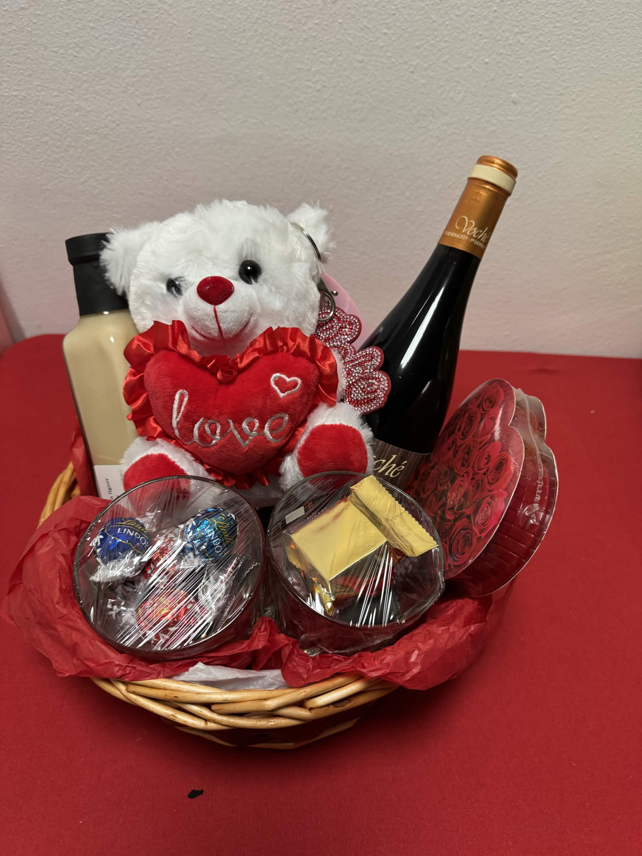 Standard Signature gift basket wrapped in blush tissue paper with a satin bow